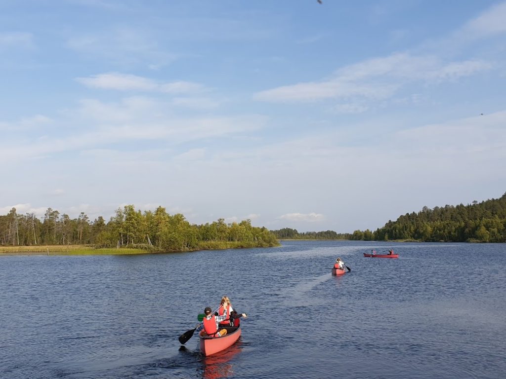 Ihmisiä melomassa kanootilla joella